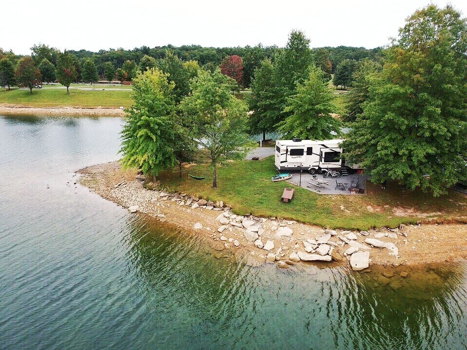 A fifth wheel RV is parked at a waterfront campsite | Photo: Nikki Kirk & Demian Ross | RV Today