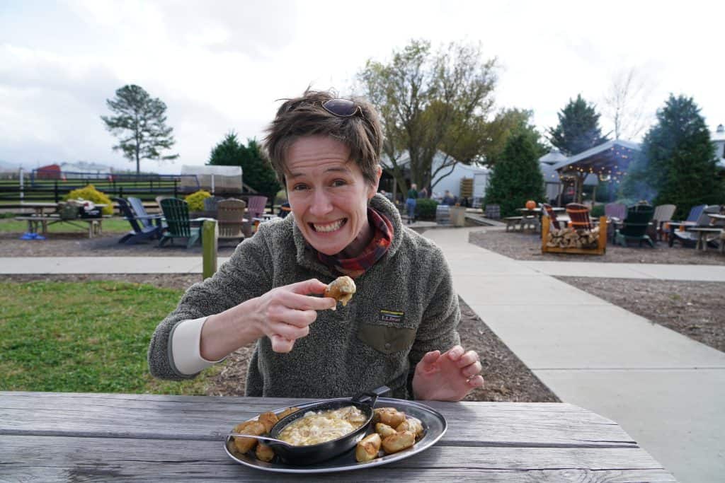 A woman smiling while enjoying food at a craft brewery near Shenandoah National Park | Photo: L. Merredith | RV Today